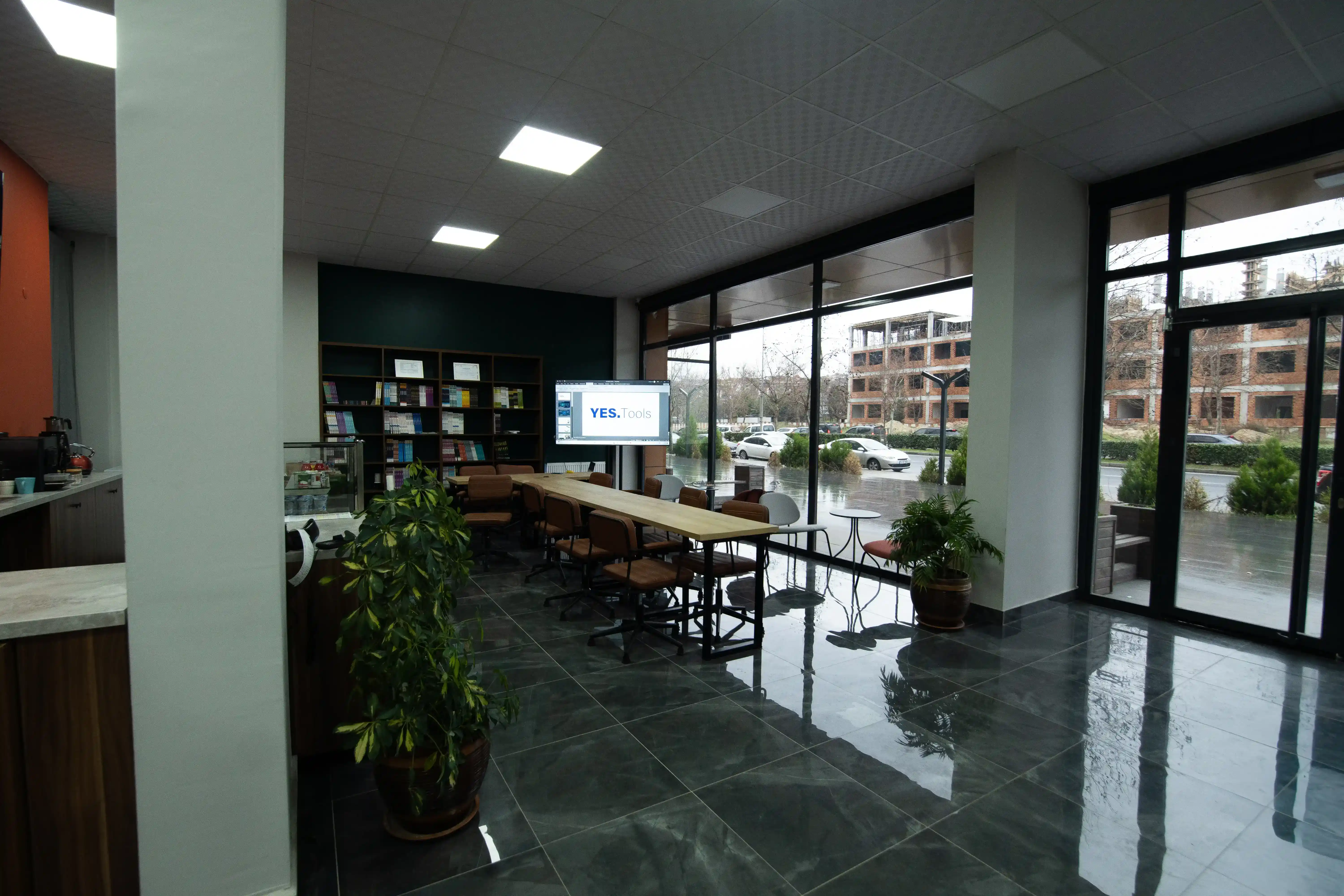 YES.Akademi kafe bölümü: çay–kahve tezgâhı, kitap rafları ve çalışma masaları